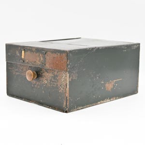 May include: A dark green metal box with a brass knob. The box has a worn, distressed finish and shows signs of age.