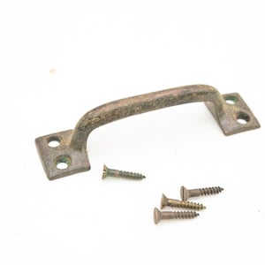May include: An antique bronze-colored handle with a curved grip and rectangular mounting plates. Four screws are scattered nearby. The hardware has a weathered appearance, suggesting age and use. Ideal for furniture restoration or vintage projects.