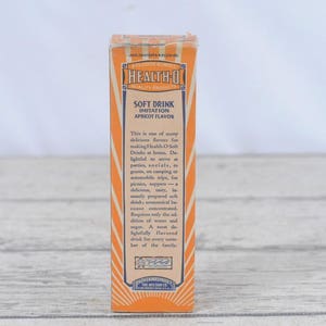 May include: A vintage box of Health O Soft Drink in imitation apricot flavor. The box is orange and white with a blue and white label. The text on the label reads "Health O Soft Drink Imitation Apricot Flavor".