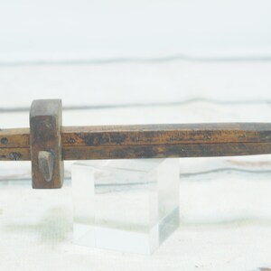 May include: A vintage wooden marking gauge with a sliding adjustable head and a metal point. The gauge is marked with inches and fractions of an inch.