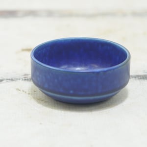 Puede incluir: Un pequeño cuenco de cerámica azul con una superficie ligeramente texturizada.