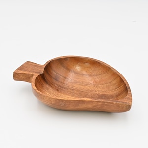 May include: A heart-shaped wooden serving dish with a handle. The dish is made of light brown wood and has a smooth, polished finish.