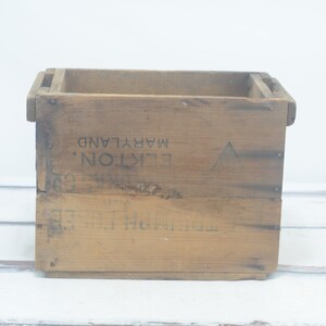 May include: A vintage wooden crate with the text "LIKTON'S" and "MARYLAND" printed on the side. The crate has a triangular symbol on the front.