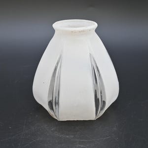 May include: Frosted glass lampshade with a flared, rounded shape. The shade has vertical, slightly recessed panels, and a textured, opaque finish. The top rim is a lighter, off-white color. The lampshade is designed for a vintage or antique lighting fixture.