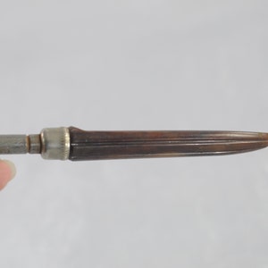 May include: A brown and silver vintage screwdriver with a wooden handle.