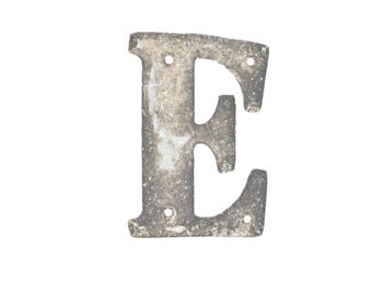 Può includere: Lettera "E" in metallo usurato con un aspetto invecchiato e usurato. La lettera è di colore grigio argento con segni di usura visibili, inclusi piccoli fori per il montaggio. Ideale per l'arredamento della casa o progetti artigianali.