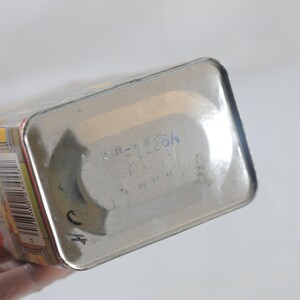 Pode incluir: Uma lata de metal prateada com um r&oacute;tulo azul e um c&oacute;digo de barras. O r&oacute;tulo tem o texto "SHEL226H" escrito nele.