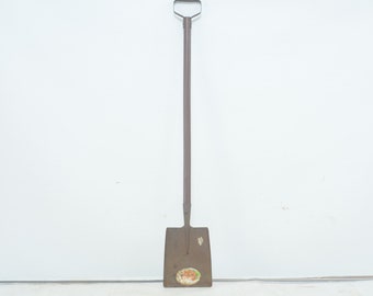 May include: A long-handled, rusty metal shovel with a square blade. The blade has a faded sticker with the text "TRUE TEMPER" on it.