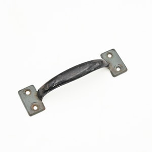 May include: A vintage black and gray metal handle with two mounting plates. The handle is curved and has a slightly worn appearance, suggesting age. The mounting plates have two holes each for attachment.