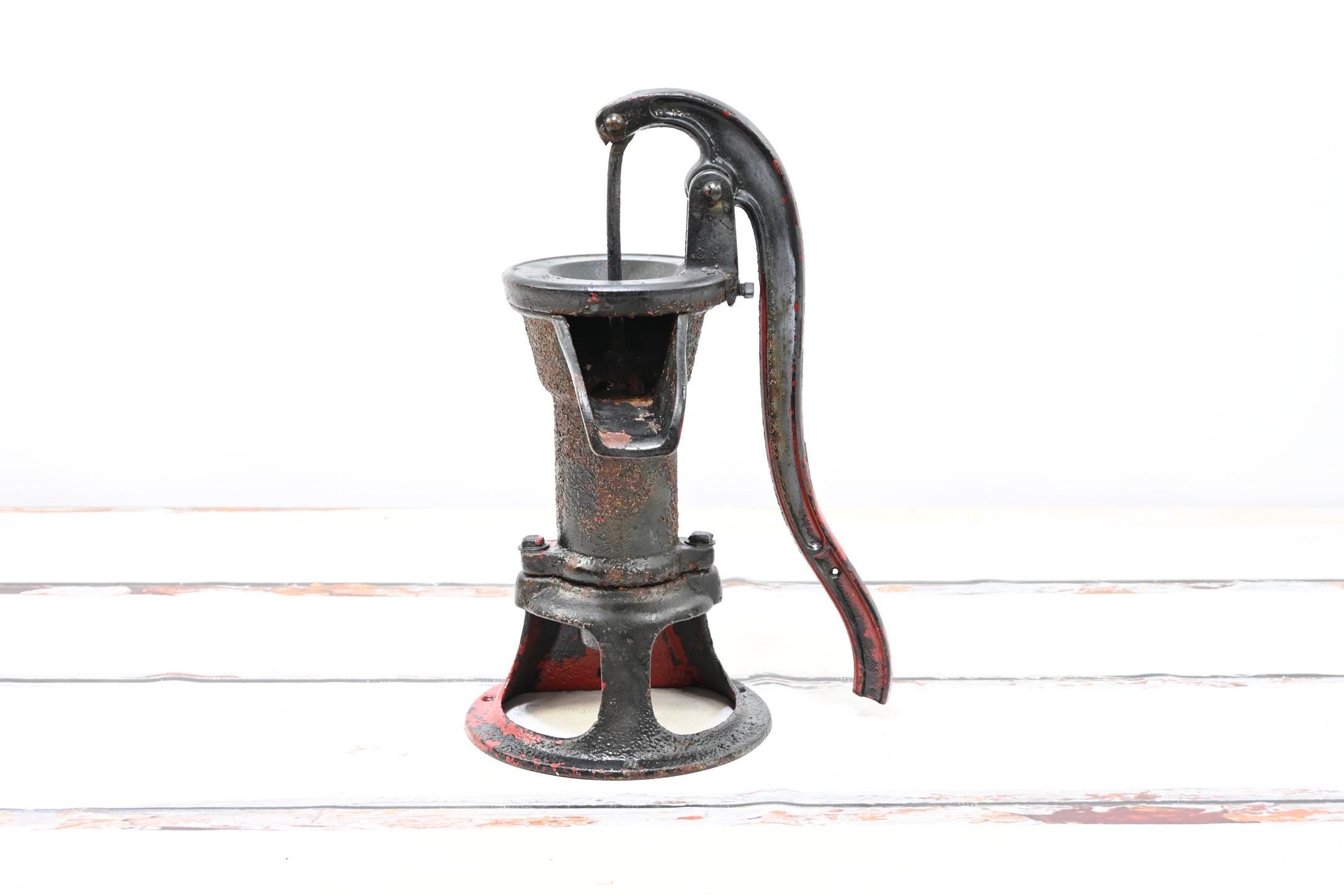 Vintage. Pompa per acqua nera con pompa rossa Vintage a mano, pompa in ghisa, decorazione di recupero