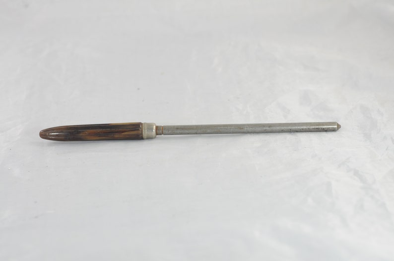 May include: A brown and black wooden handled steel knife sharpener.