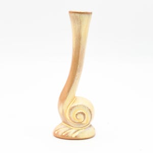 May include: A ceramic vase in a light yellow colour with a curved neck and a spiral base.
