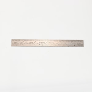 Puede incluir: Una regla de acero inoxidable con marcas y texto grabados. La regla está marcada con medidas en pulgadas y fracciones de pulgada. El texto incluye "SIMPLIFIED RULE CO. PHILA PA" y "PATENTED JULY 28 1931".