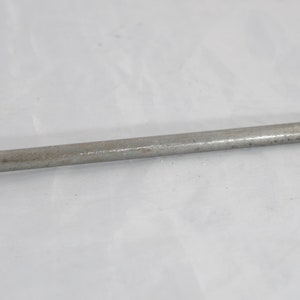 May include: A silver metal tool with a pointed tip and a threaded end. The tool is about 10 inches long.