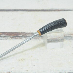 May include: A silver knife sharpener with a black and brown antler handle.