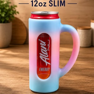 May include: A slim 12oz can holder featuring a gradient blue to pink exterior with a side handle. The holder has a vertical cutout window revealing an Alani Nu energy drink can inside. Text at the top reads CAN HOLDER 12oz SLIM.