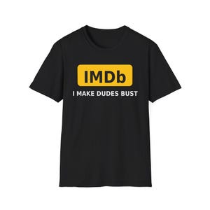 May include: A black short-sleeved t-shirt featuring a yellow rectangular graphic with the black text IMDb inside. Below the yellow rectangle, the white text reads I MAKE DUDES BUST. The shirt has a crew neckline and a standard straight hemline.