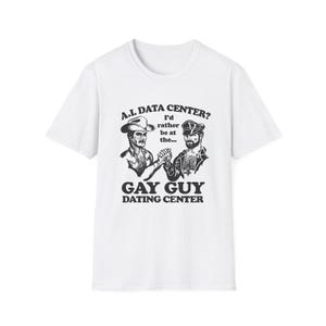 May include: A white short-sleeved t-shirt featuring a black graphic print of two men shaking hands. The text reads: A.I. DATA CENTER? I'd rather be at the... GAY GUY DATING CENTER. The illustration depicts one man in a cowboy hat and one in a leather cap.