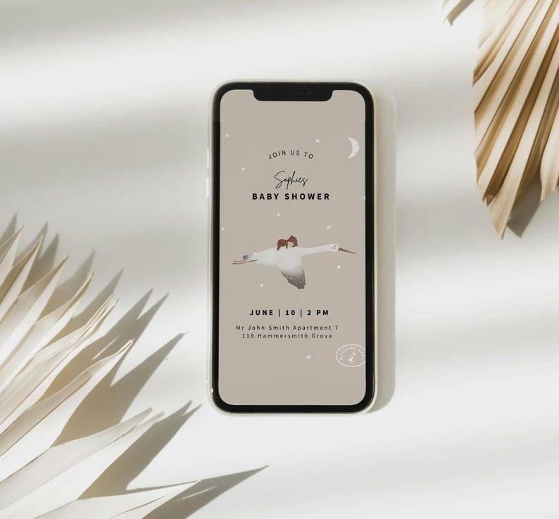May include: A smartphone displays a baby shower invitation. The invitation features the text "Join us to Sophie's Baby Shower" with a graphic of a stork carrying a baby. The date and time are also included.