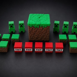Peut inclure: Ensemble de figurines et de blocs sur le thème de Minecraft. L'ensemble comprend des figurines Creeper vertes, des blocs d'herbe verts et bruns, des blocs de TNT rouges avec du texte blanc et un grand bloc d'herbe. Les objets sont disposés sur une surface noire.