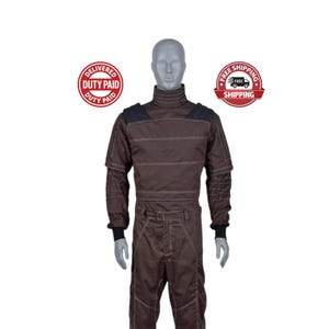 May include: Brown racing suit with white stitching and black accents. The suit features a high collar, long sleeves, and a belt. The suit is displayed on a mannequin.