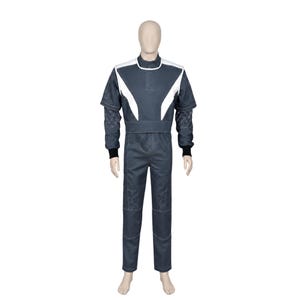 May include: A dark gray jumpsuit featuring a high collar, white angular shoulder panels, and short sleeves layered over long sleeves with a geometric triangular pattern. The garment includes black ribbed cuffs at the wrists and a fitted waistline.