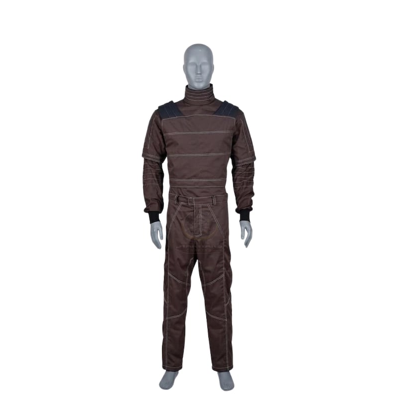 May include: A brown racing suit on a mannequin. The suit has a high collar, long sleeves, and trousers with white stitching. Black accents are on the shoulders and wrists. The suit is designed for motorsports.