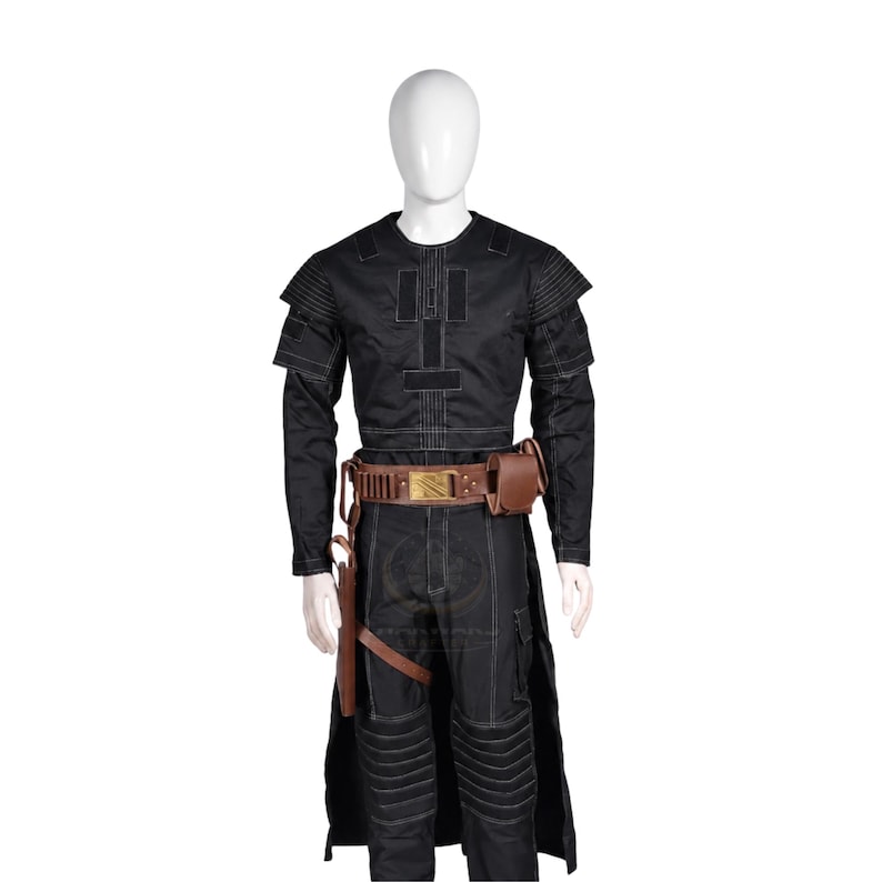 Puede incluir: Una camisa t&aacute;ctica negra de manga larga y pantalones a juego con costuras blancas en contraste, usados con un cintur&oacute;n utilitario de cuero marr&oacute;n con hebilla dorada, una funda y una peque&ntilde;a bolsa, exhibidos en un maniqu&iacute; blanco.