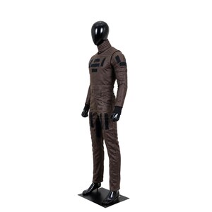 May include: A brown long-sleeved jumpsuit on a black mannequin. The garment features a high collar, black rectangular patches on the chest and thighs, and black ribbed cuffs at the wrists. The fabric has a textured appearance with visible seams.