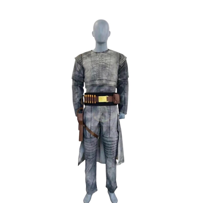 May include: A gray costume displayed on a mannequin. The outfit includes a long-sleeved top, pants, and a belt with ammunition. A holster with a gun is attached to the belt. The costume has a weathered appearance, suggesting a vintage or battle-worn aesthetic.