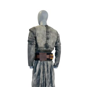 May include: A gray denim jacket with long sleeves and a cropped waist, paired with a matching skirt. A brown leather belt with gold-colored accents is worn at the waist. The outfit is displayed on a mannequin.
