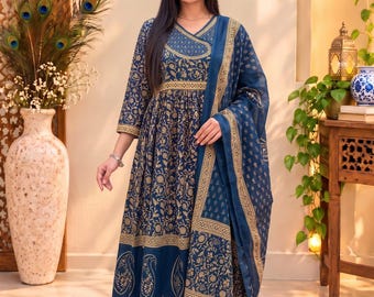 Puede incluir: Un vestido azul marino hasta la rodilla con estampado floral dorado, con mangas tres cuartos, cuello en V y una dupatta transparente a juego. El vestido se combina con pantalones azul marino a juego con un dobladillo dorado.