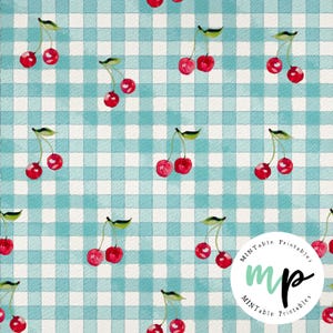 Puede incluir: Un patrón repetido de cerezas de acuarela con tallos y hojas verdes sobre un fondo a cuadros azul claro y blanco. Las cerezas son de color rojo vibrante. El diseño recuerda a una manta de picnic.