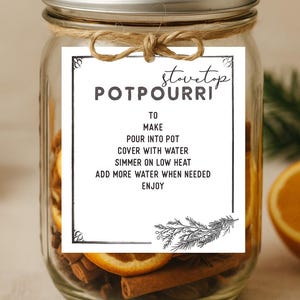 Könnte beinhalten: Ein Glas mit Potpourri-Zutaten, darunter Zimtstangen und Orangenscheiben. Ein Etikett trägt die Aufschrift "Stovetop Potpourri" mit Anweisungen. Das Glas ist mit Bindfaden gebunden und hat einen silbernen Deckel.