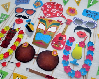 May include: A set of 14 colorful paper photo booth props with a tropical theme. The props include a lei, a coconut, a tiki mask, a ukulele, a surfboard, sunglasses, mustaches, lips, and a flower crown.
