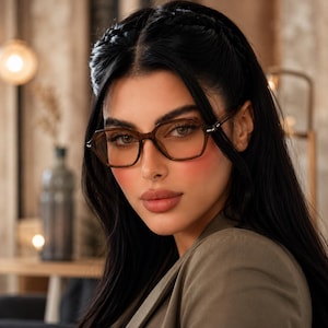 May include: A pair of brown-tinted spectacles with a geometric frame shape. The glasses feature a translucent brown frame with thin temples and a bridge that connects the two lenses. The lenses have a subtle brown tint and a clear finish.