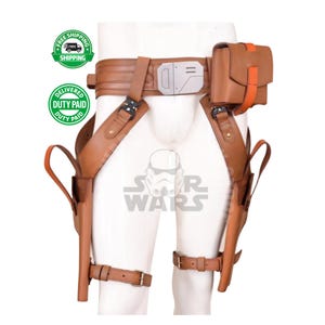May include: A brown leather utility belt and holster set. The belt features a silver buckle, a small pouch with an orange strap, and two holsters with leg straps. The Star Wars logo is visible.