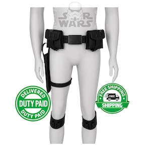 Op de afbeelding: Zwarte gereedschapsriem met twee zakjes, een holster en been- en knieaccessoires. De riem heeft een rechthoekige gesp. De accessoires worden op een mannequin getoond. Het Star Wars-logo is zichtbaar op de achtergrond.