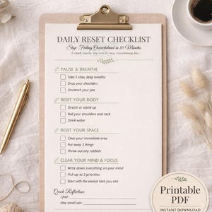May include: A printable PDF checklist titled "Daily Reset Checklist" with instructions to stop feeling overwhelmed in 10 minutes. The checklist includes steps for pausing, breathing, resetting the body, space, and mind. A cup of coffee and a pen are also visible.