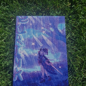 Puede incluir: Una impresión rectangular con un personaje de anime estilizado con un traje y sombrero azul oscuro, de pie bajo un gran árbol con efectos de luz brillante. El texto vertical "FURINA" está impreso en una fuente azul y morada a la izquierda.