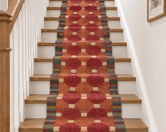 Puede incluir: Una alfombra larga para escaleras con un patrón geométrico repetitivo de grandes octágonos de color rojo oscuro conectados por pequeños cuadrados beige sobre un fondo naranja quemado, con bordes a rayas multicolores en tonos azul, verde y amarillo.