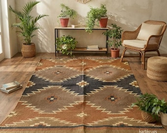 Puede incluir: Una alfombra rectangular con un patrón geométrico en tonos marrón, bronceado y gris oscuro, con un borde de flecos. La alfombra muestra un motivo de diamante repetido en toda su superficie, creando una apariencia texturizada en el suelo.