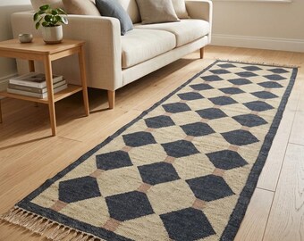Puede incluir: Una alfombra de pasillo rectangular con un patrón geométrico repetitivo de diamantes en azul marino oscuro y beige natural. La alfombra está terminada con flecos cortos de color claro en ambos extremos cortos, creando un borde texturizado.