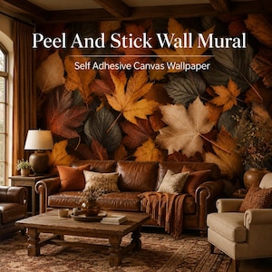 May include: A room featuring a peel and stick wall mural with a self-adhesive canvas wallpaper design. The mural showcases large, colorful autumn leaves in shades of brown, orange, and green. A brown leather sofa, wooden coffee table, and beige armchair complete the cozy interior.