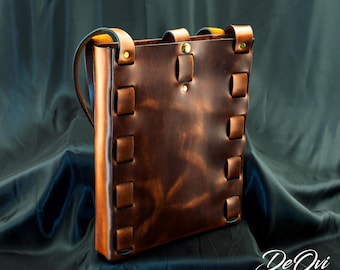 May include: A rectangular brown leather bag featuring a vertical woven strap design along the sides, a single top center snap closure, and a shoulder strap. The leather has a smooth, polished finish with visible tonal variations in the brown color.