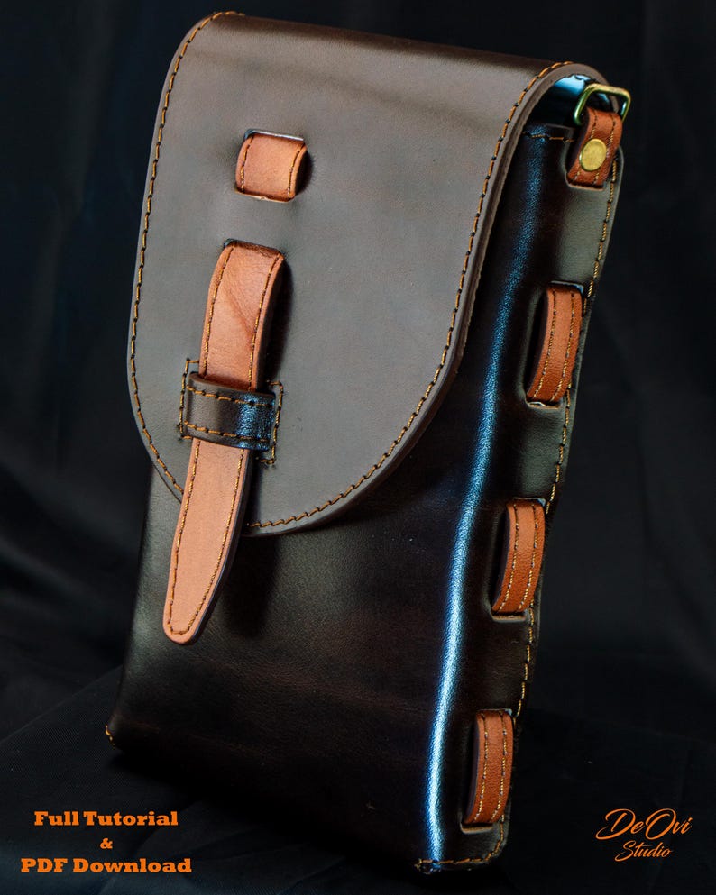 May include: A dark brown leather pouch featuring a lighter tan leather strap closure and side accents. The pouch has visible stitching along the edges and a brass-colored metal ring at the top. Text at the bottom reads Full Tutorial & PDF Download De Ovi Studio.