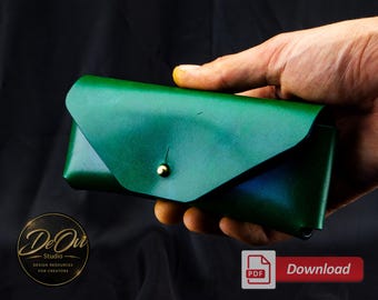May include: A rectangular green leather glasses case with a pointed envelope-style flap closure secured by a single gold-toned metal stud. The case features a smooth finish and a structured design, held in a hand against a dark background.