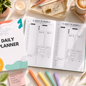 May include: A white daily planner with the words "DAILY PLANNER" in black. The planner is open to reveal lined pages for scheduling. The cover has colorful abstract shapes. Other items include pens, a coffee cup, and sticky notes with the words "focus, plan, breathe, do my best."