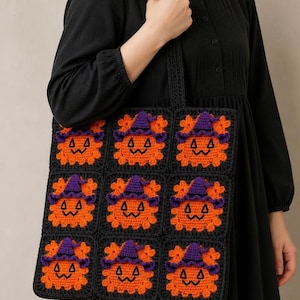 Puede incluir: Un bolso de ganchillo negro con una cuadrícula de nueve motivos cuadrados. Cada cuadrado muestra una calabaza naranja con un sombrero de bruja morado y rasgos faciales bordados en negro. El bolso tiene una correa de ganchillo negra.