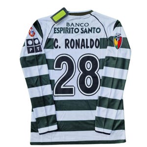 May include: White and green striped long-sleeve soccer jersey with the name "C. Ronaldo" and the number "28" on the back. The jersey has sponsor logos and a "Liga" patch. A tag is attached to the collar.
